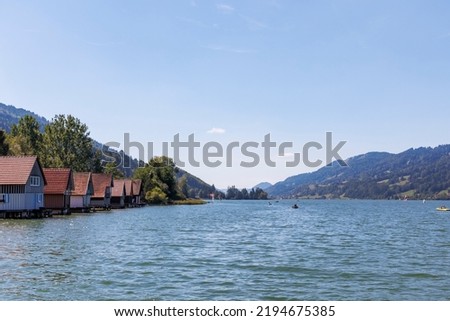 Colorful wooden boathouses with jetty at the Alpsee near Immenstadt Royalty-Free Stock Photo #2194675385