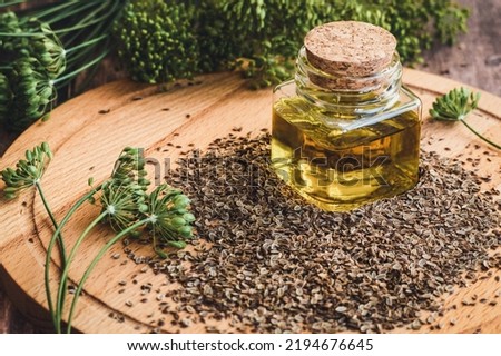 Dill seed oil, organic dill plant flowers and dry seeds, Indian traditional medicinal herb and spice on wooden table Royalty-Free Stock Photo #2194676645