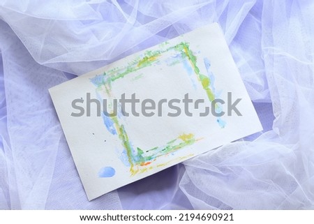 white paper sheet with aquarelle frame on white tulle with violet background