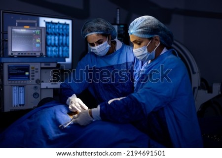 Two female surgeons performing surgery at hospital operating room