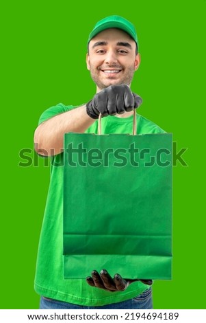 Delivery man with paper bag. Courier in uniform cap and t-shirt, gloves service fast delivering orders. Young guy holding a paper package. Character on isolated background for mockup design