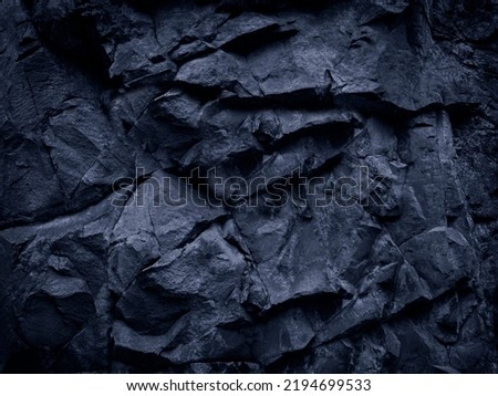   Dark blue rock texture. Toned the rough surface of the mountain. Close-up. Granite stone background for design. Solid. Wallpaper.                             