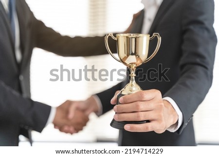 The hands of an employee receiving a golden cup reward from the company manager represent his performance in his career job reward. Royalty-Free Stock Photo #2194714229