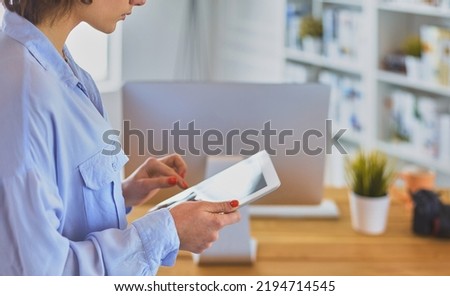 Portrait of an attractive professional photographer woman and using a tablet