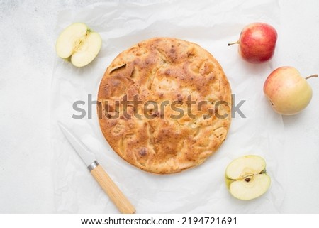 Homemade Apple pie with apples and knife on white background. Top view.