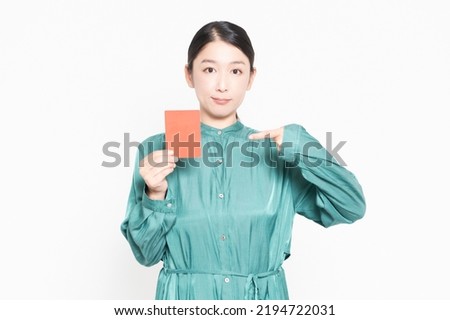 A housewife showing a red card in front of a white background Royalty-Free Stock Photo #2194722031