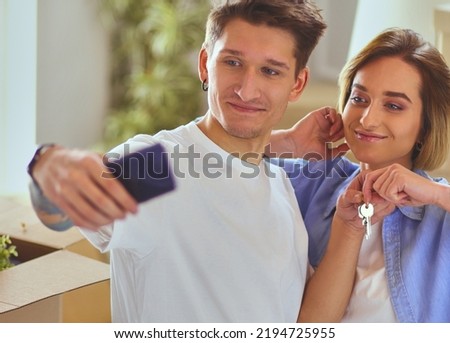 A young couple makes selfie while moving to a new apartment.