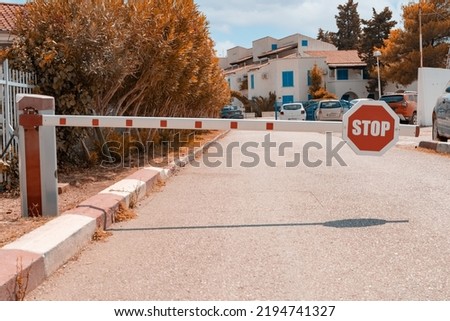 a barrier with a round stop sign protecting the private area from suspicious people. Fencing for the entry of cars into a closed protected area.