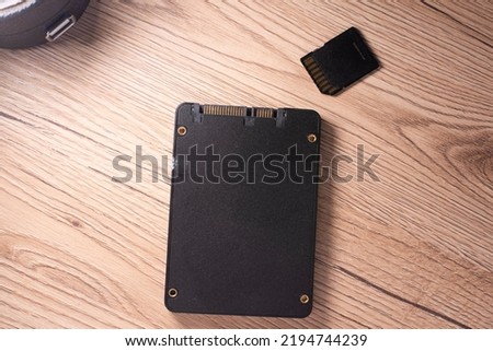 ssd hard drive and sd memory card on wooden table