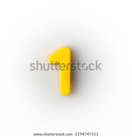 Plastic magnetic number 1 one yellow on a white background top view.