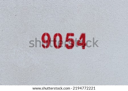 Red Number 9054 on the white wall. Spray paint.
