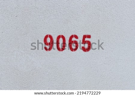 Red Number 9065 on the white wall. Spray paint.
