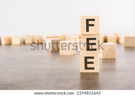 FEE text as a symbol on cube wooden blocks. many wooden blocks in the background
