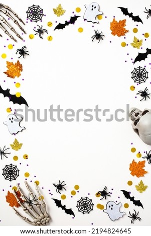 Happy Halloween holiday concept. Frame made of Halloween decorations, bats, ghosts, spiders on white background. Halloween poster design.