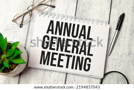 notepad with the word AGM Annual general meeting written on it on a white background Royalty-Free Stock Photo #2194837043