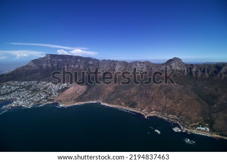 wide angel aerial view of rocky coast line from Camps Bay Cape Town along the 12 apostles and table Mountain View, blue sea and blue sky
