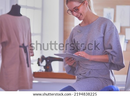 Fashion young designer woman measuring a dress