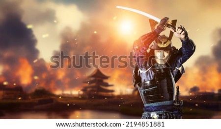 A castle on fire and a samurai drawing a sword. The concept of a Japanese period drama. The Sengoku period. Royalty-Free Stock Photo #2194851881