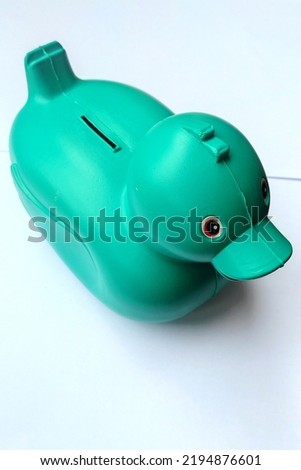 green plastic duck - toy for saving money close up isolated on white