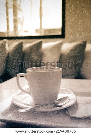 a photo of coffee in white mug on table with texture