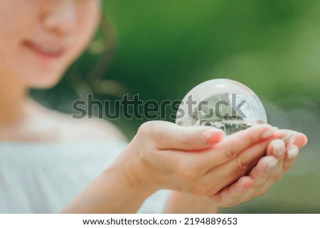 Asian woman in white clothes holding a globe (ecology)
