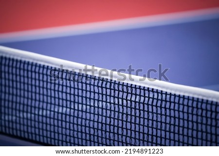 Blue and smooth surface table tennis table with tight black net to being prepared for practice and competition.