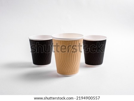 Coffee cups of different colors on a white background. Disposable dishes for hot drinks. Logo model.