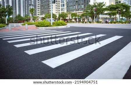 pedestrian crossing, white stripes on black asphalt, road markings zebra crossing, place to cross the road, traffic rules Royalty-Free Stock Photo #2194904751