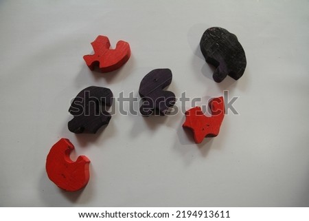 a wooden toy puzzle with a black and red worm shape is useful for training children's psychomotor skills