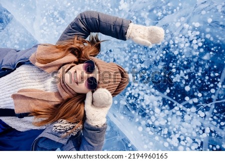 Adventure Tourist woman background ice with gas methane bubbles lake Baikal winter travel.