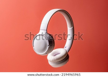 Wireless white headphones background on the pink close up. Royalty-Free Stock Photo #2194965965