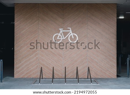 Front view of a large sign for bicycle parking on the wall. Bicycle parking in city.