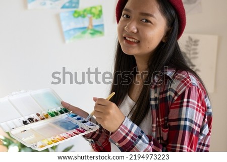 Young girl painting on paper at home, wood frame,Hobby and art study at home.
