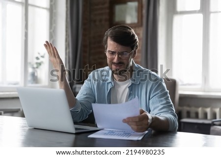 Stressed angry business leader man reading paper report, getting bad news, problems, bankruptcy, financial loss, bank rejection. Businessman finding mistake in paper document, contract text Royalty-Free Stock Photo #2194980235