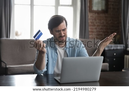 Annoyed frustrated bank customer man using laptop, reading message, notice about problem with credit card, blocked account, counting expenses, loss, getting financial overspending, bankruptcy Royalty-Free Stock Photo #2194980279