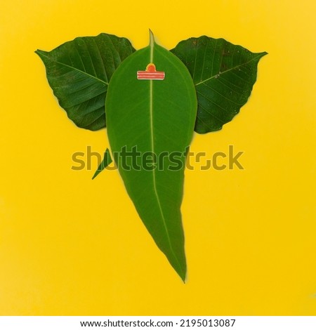 handmade leaf ganpati on yellow background, vinayagar chaturthi special.