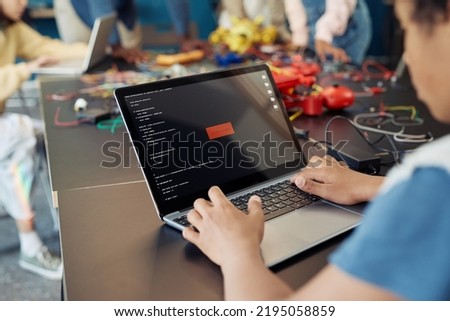 Close up of boy using laptop in engineering class with Access denied notification, copy space