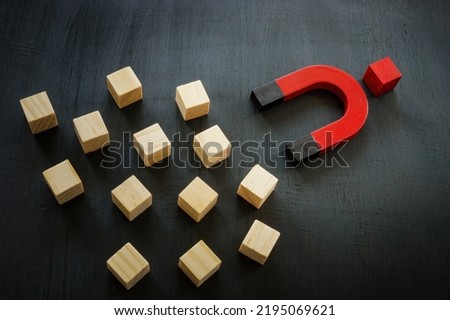 Cubes, a magnet and one red cube. Charismatic leadership. Royalty-Free Stock Photo #2195069621