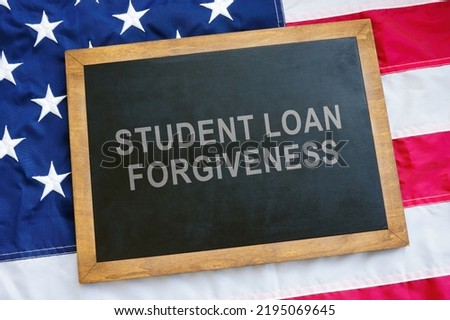 Student loan forgiveness concept. USA flag and blackboard on it. Royalty-Free Stock Photo #2195069645