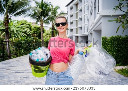 Young beautiful girl takes out the sorted garbage from the house