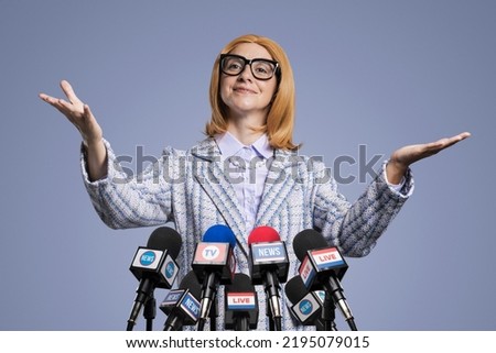 Smiling female politician holding a press conference, she is smiling and gesturing Royalty-Free Stock Photo #2195079015