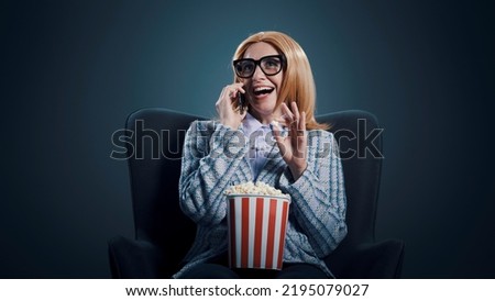 Funny rude woman talking with her smartphone at the movie theater Royalty-Free Stock Photo #2195079027