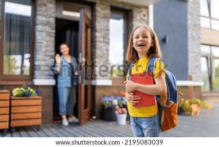Parent and pupil of primary school going hand in hand. Woman and girl with backpack behind the back. Beginning of lessons. Royalty-Free Stock Photo #2195083039