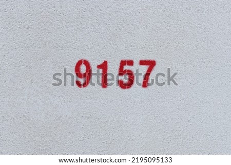 Red Number 9157 on the white wall. Spray paint.

