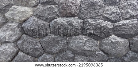 Natural dark charcoal coarse slate stone masonry wall texture as a building wall finishes.