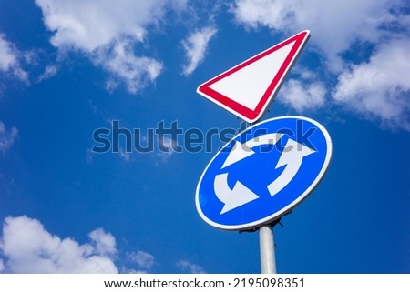 priority road car signs to regulate traffic, shot against the sky close-up