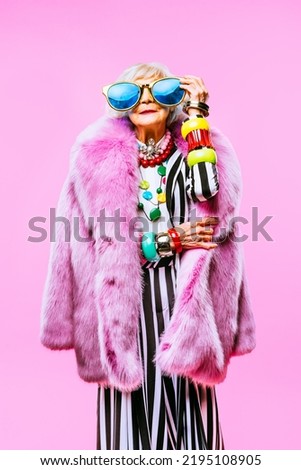 Happy and funny cool old lady with fashionable clothes portrait on colored background - Youthful grandmother with extravagant style, concepts about lifestyle, seniority and elderly people Royalty-Free Stock Photo #2195108905