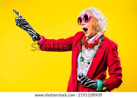 Happy and funny cool old lady with fashionable clothes portrait on colored background - Youthful grandmother with extravagant style, concepts about lifestyle, seniority and elderly people Royalty-Free Stock Photo #2195108909