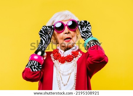 Happy and funny cool old lady with fashionable clothes portrait on colored background - Youthful grandmother with extravagant style, concepts about lifestyle, seniority and elderly people Royalty-Free Stock Photo #2195108921