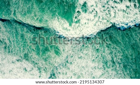 Drone view over ocean waves , on summer sunny day. Top view to the beautiful green Atlantic Ocean. Aerial view: Big sea waves with foam, closeup view.	